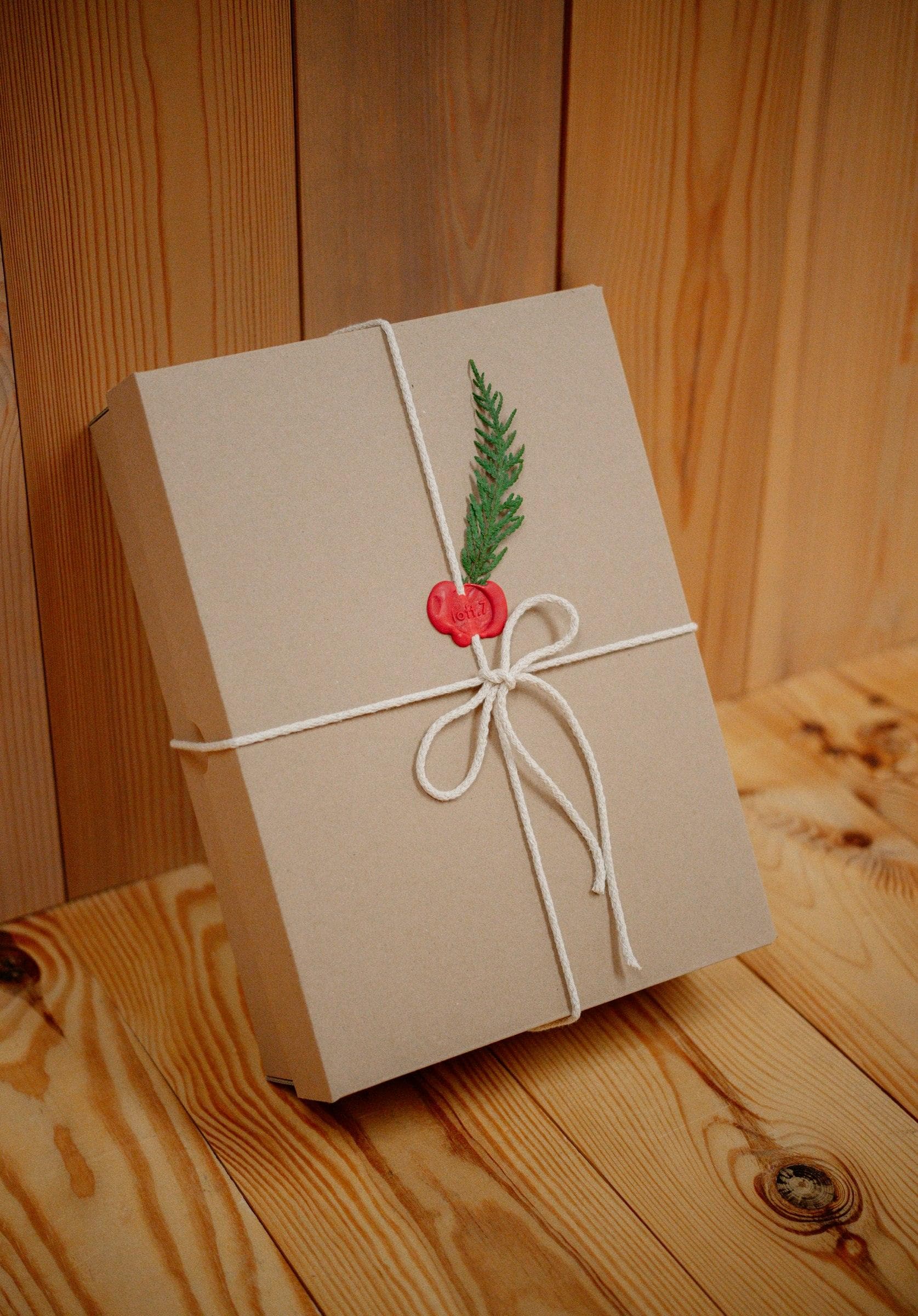 Cadeau emballé de papier kraft, noué d'une ficelle et d'un brin de sapin