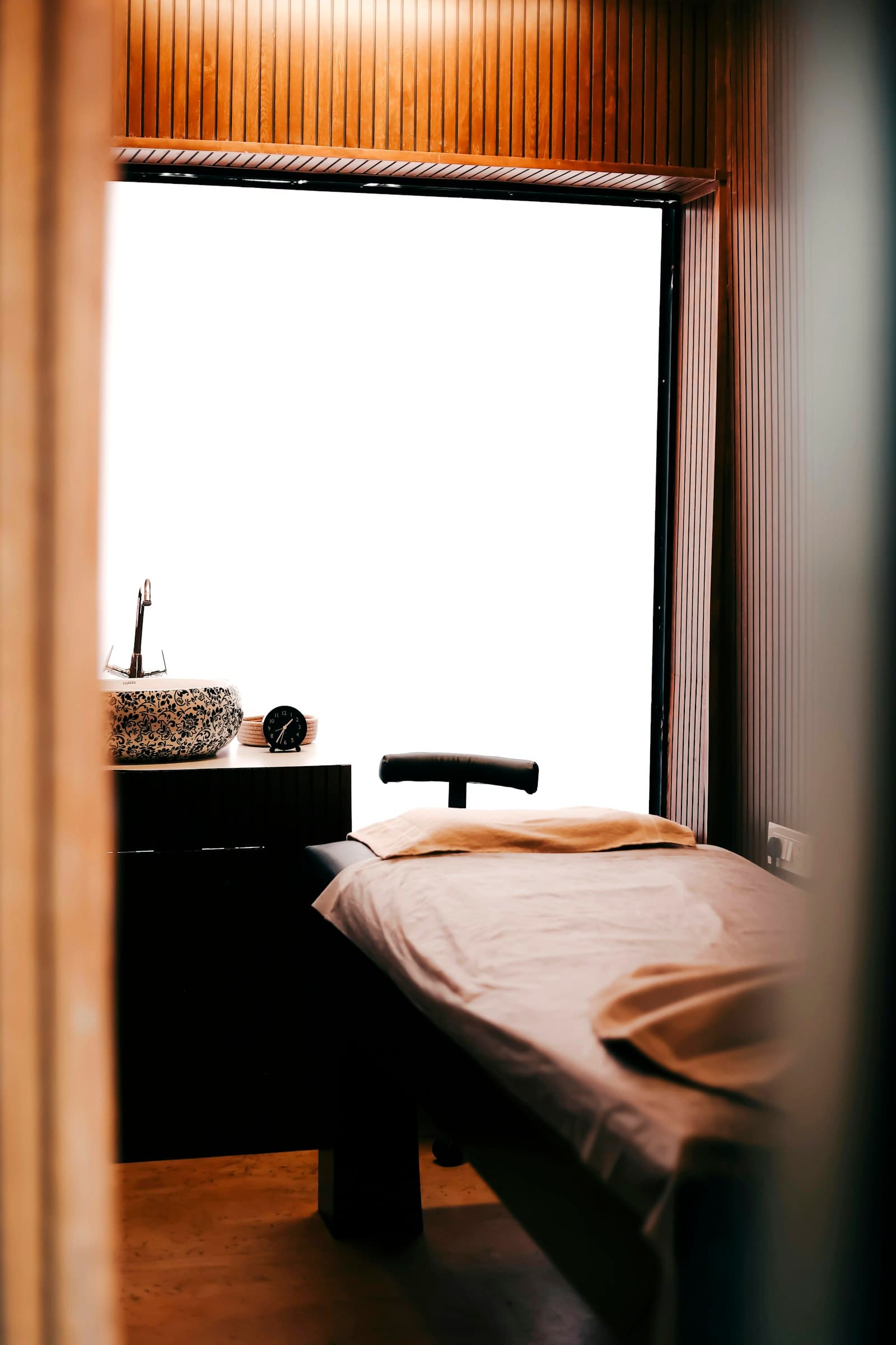 Cabine de soin paisible avec une table de massage et des murs en bois
